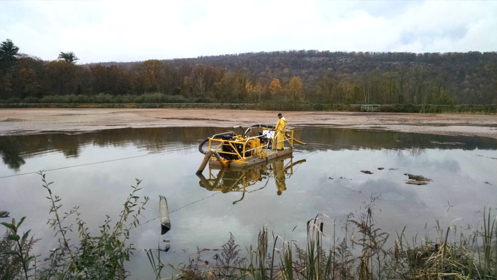 Man on dredge in middle of lake